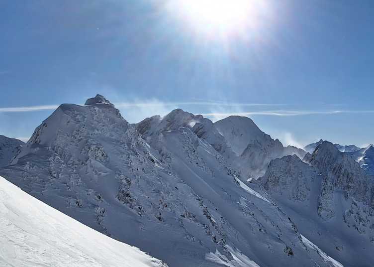 Enlarged view: Snow plumes around mountain silhouettes evidence wind-driven snow transport, a major driver of spatial variability of accumulation.